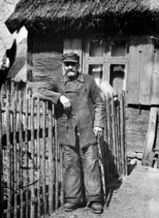 Gospodarz na tle chaty