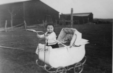 W wózku Inge Tofahr na tle stodoły w gospodarstwie dziadka, Friedricha Kalffa