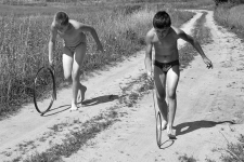 Norbert and Pawel Maziejuk rolling a rim from a bicycle wheel and a pipe