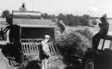 Żniwa w gospodarstwie Franciszka Kapiszki. Fotoreporter Jan Maziejuk siedzi na kabinie ciągnika