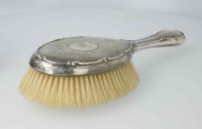 Yellow bristle brush in oval frame with MG monogram